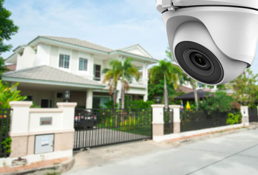 A home front blurred in the background with a camera in clear view in the foreground.